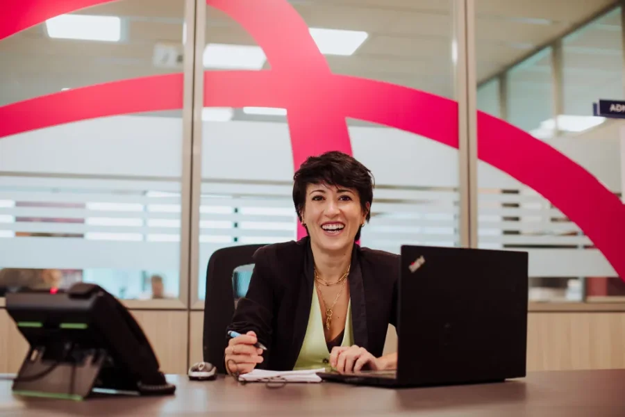 Consultant smiling at her desk in a Fiabilis office